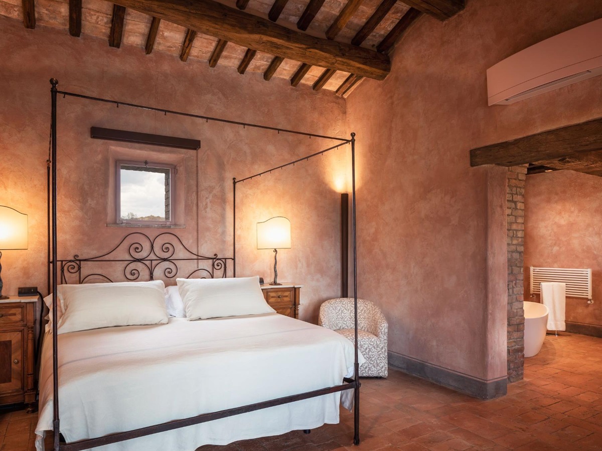 Double bedroom with black bed frame at Podere Martino in Tuscany