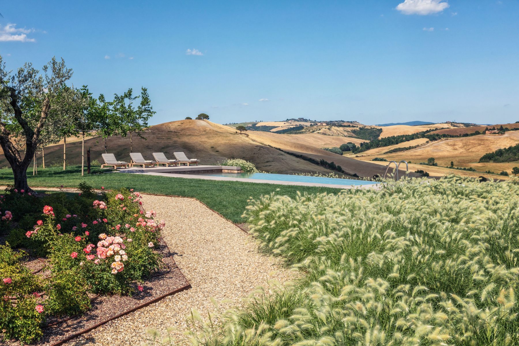 Path leading to swimming pool with views over Tuscan hills at private villa Podere Martino in Tuscany