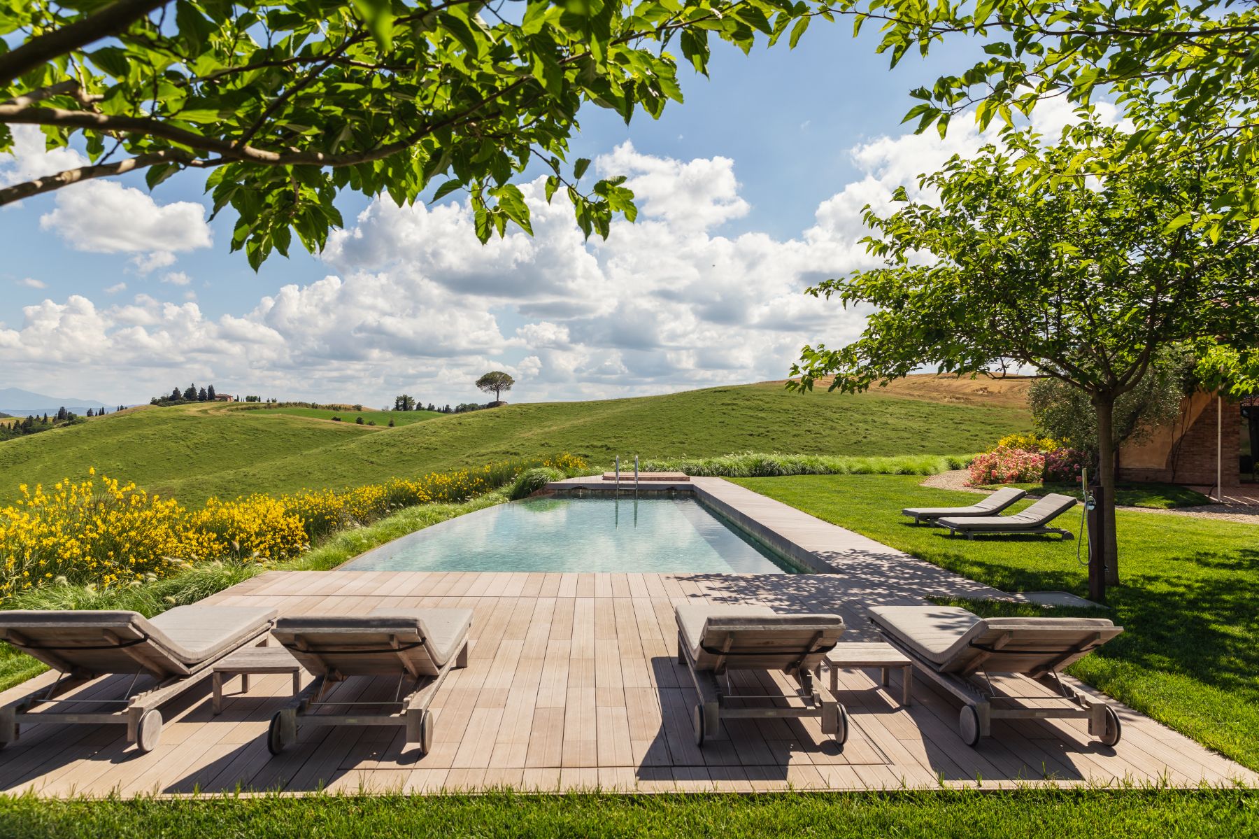 Pool loungers with view over the pool at luxury villa Podere Martino in Tuscany