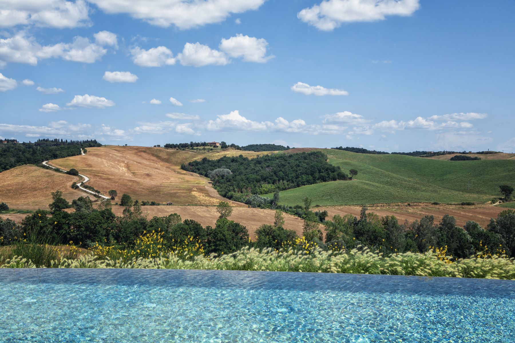 View from pool looking out over beautiful Tuscan scenery at luxury villa Podere Martino in Tuscany