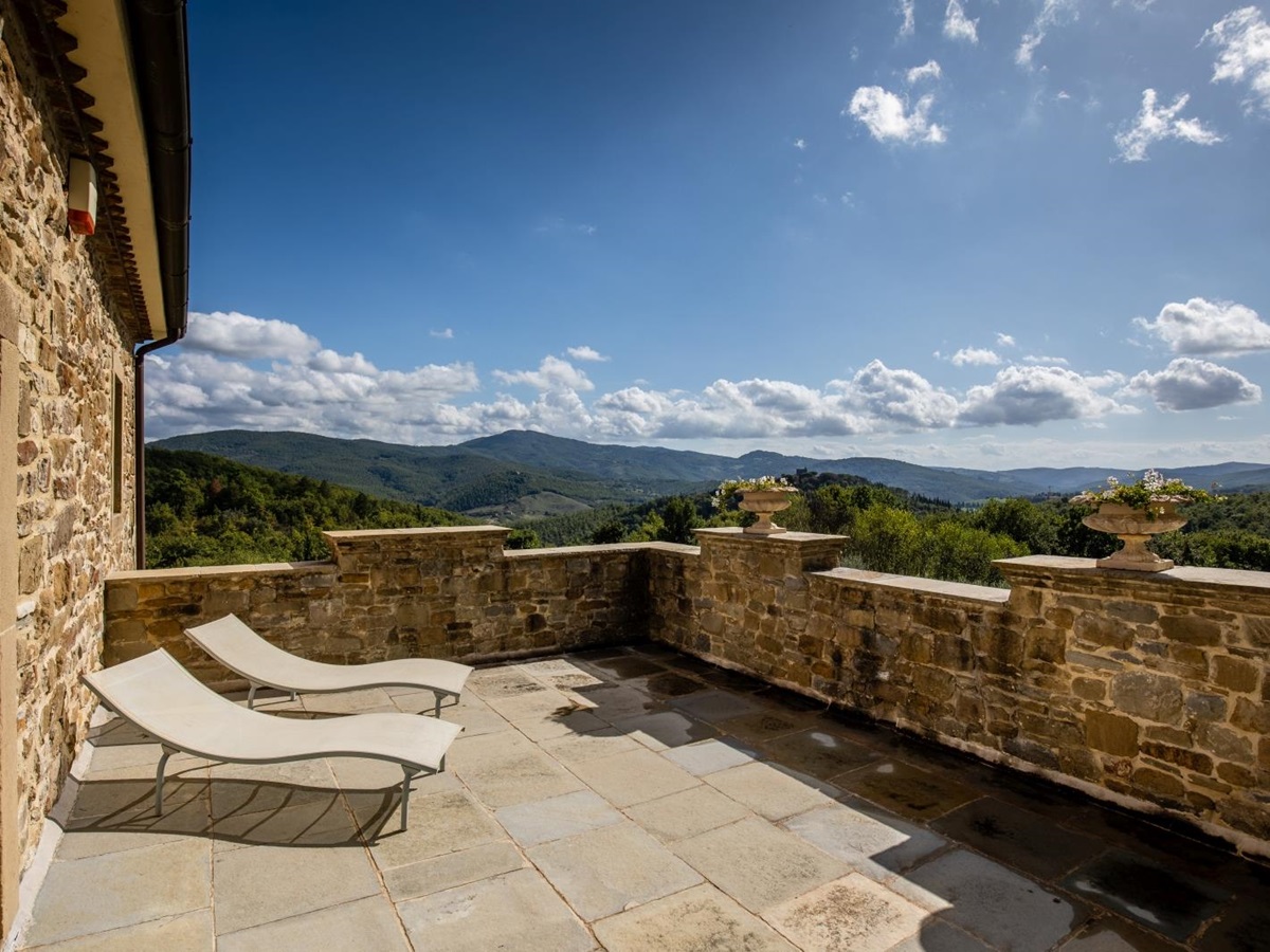 Stone balcony with two sun loungers and mountain view at Tenuta Cantata in Tuscany, Italy