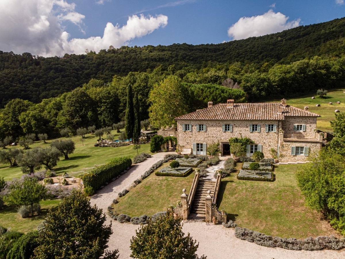 Aerial view of villa with gardens, trees, forest, flowers, pool, patio and driveway at Tenuta Cantata in Tuscany, Italy