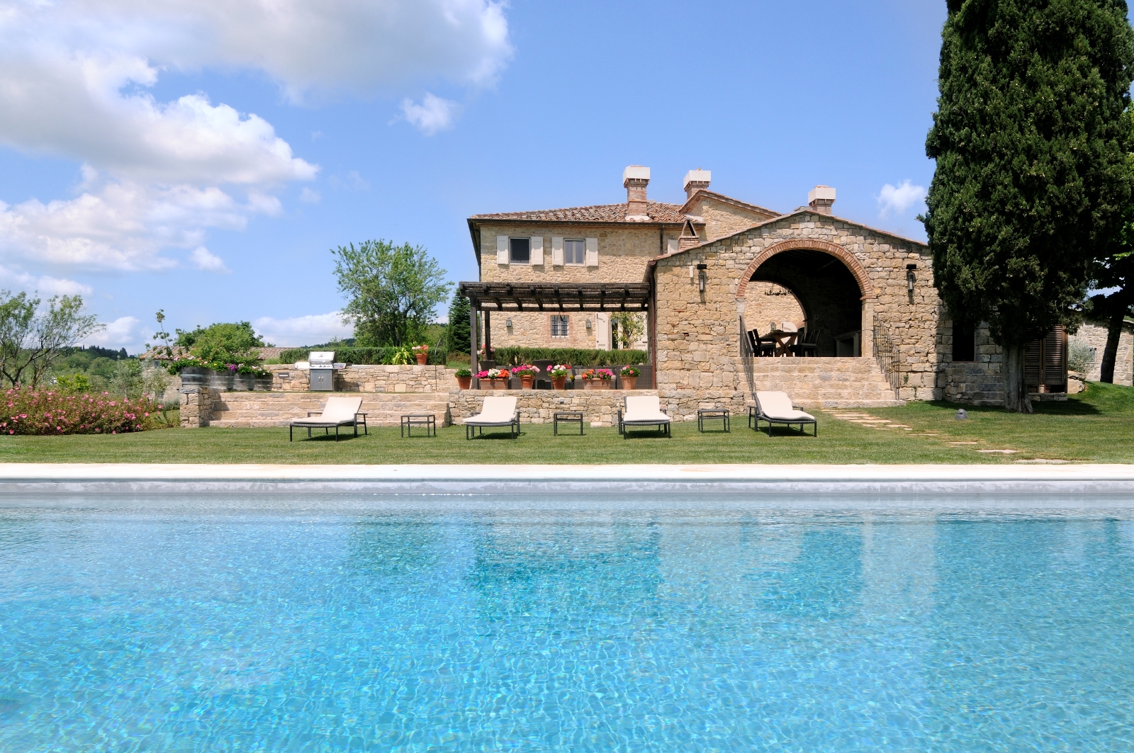 The swimming pool, sun loungers and facade of Tramonti, Tuscany