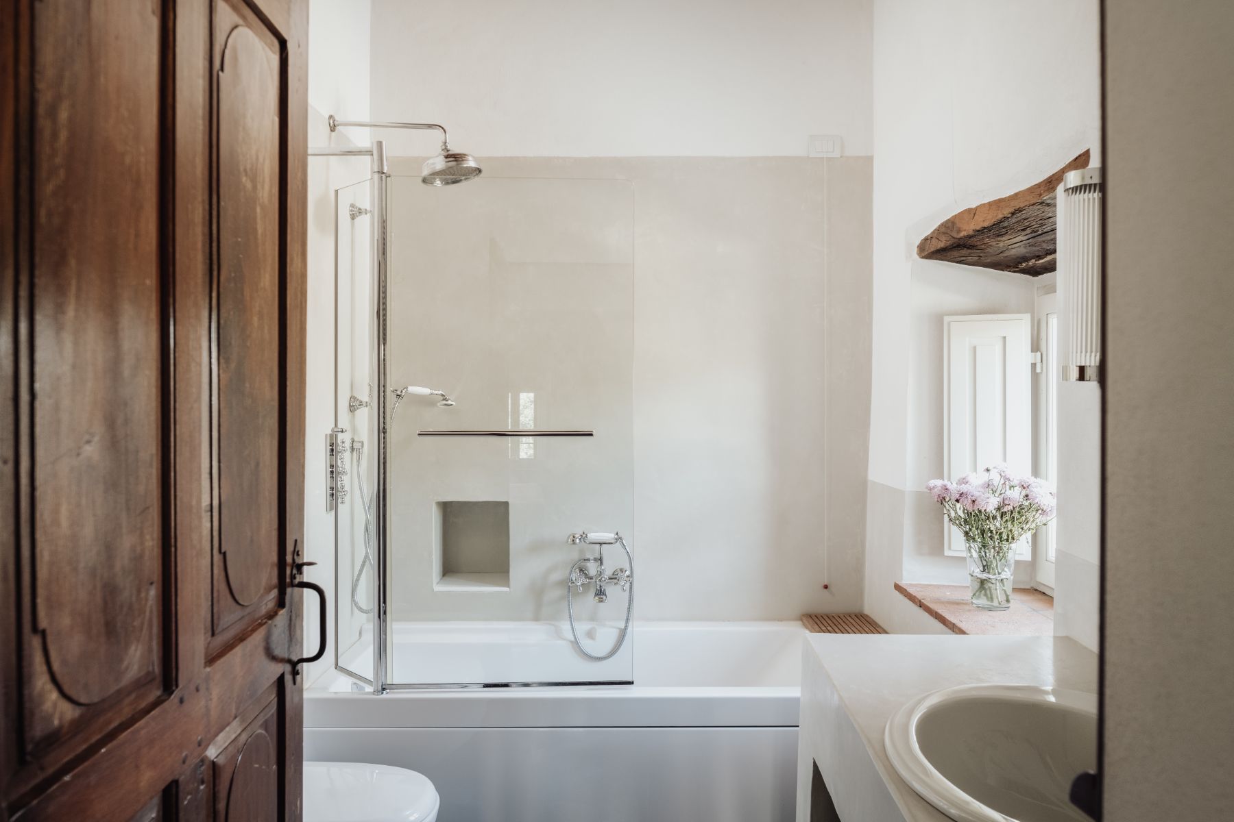 Ensuite bathroom with bath tub and shower head with basin at Tramonti in Tuscany