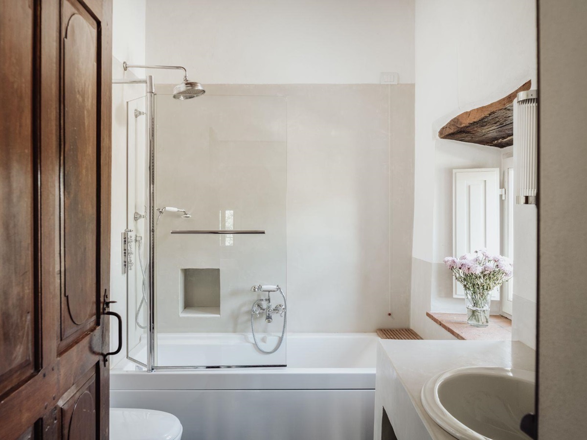Ensuite bathroom with bath tub and shower head with basin at Tramonti in Tuscany