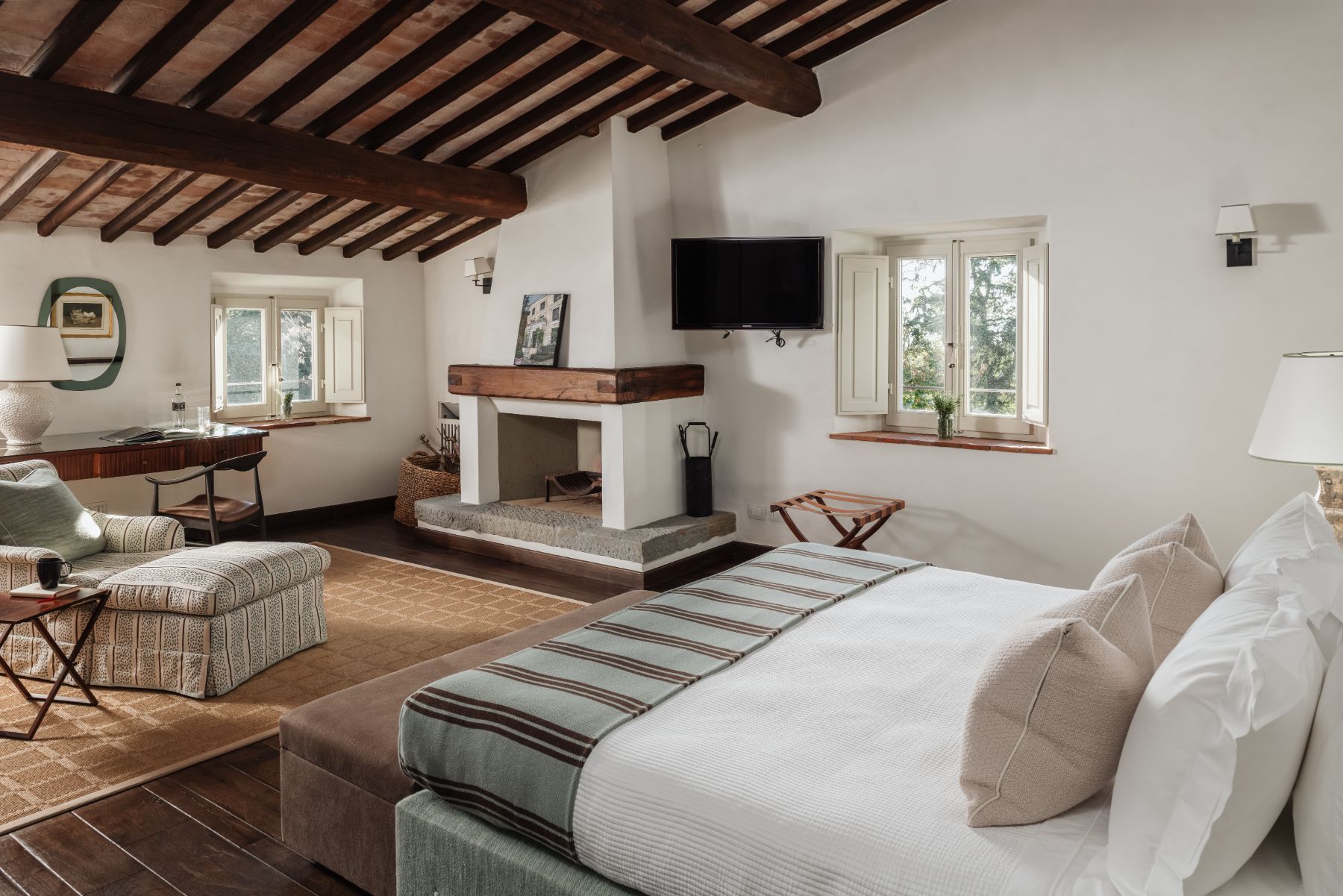 Large bedroom with double bed and fireplace at Tramonti in Tuscany