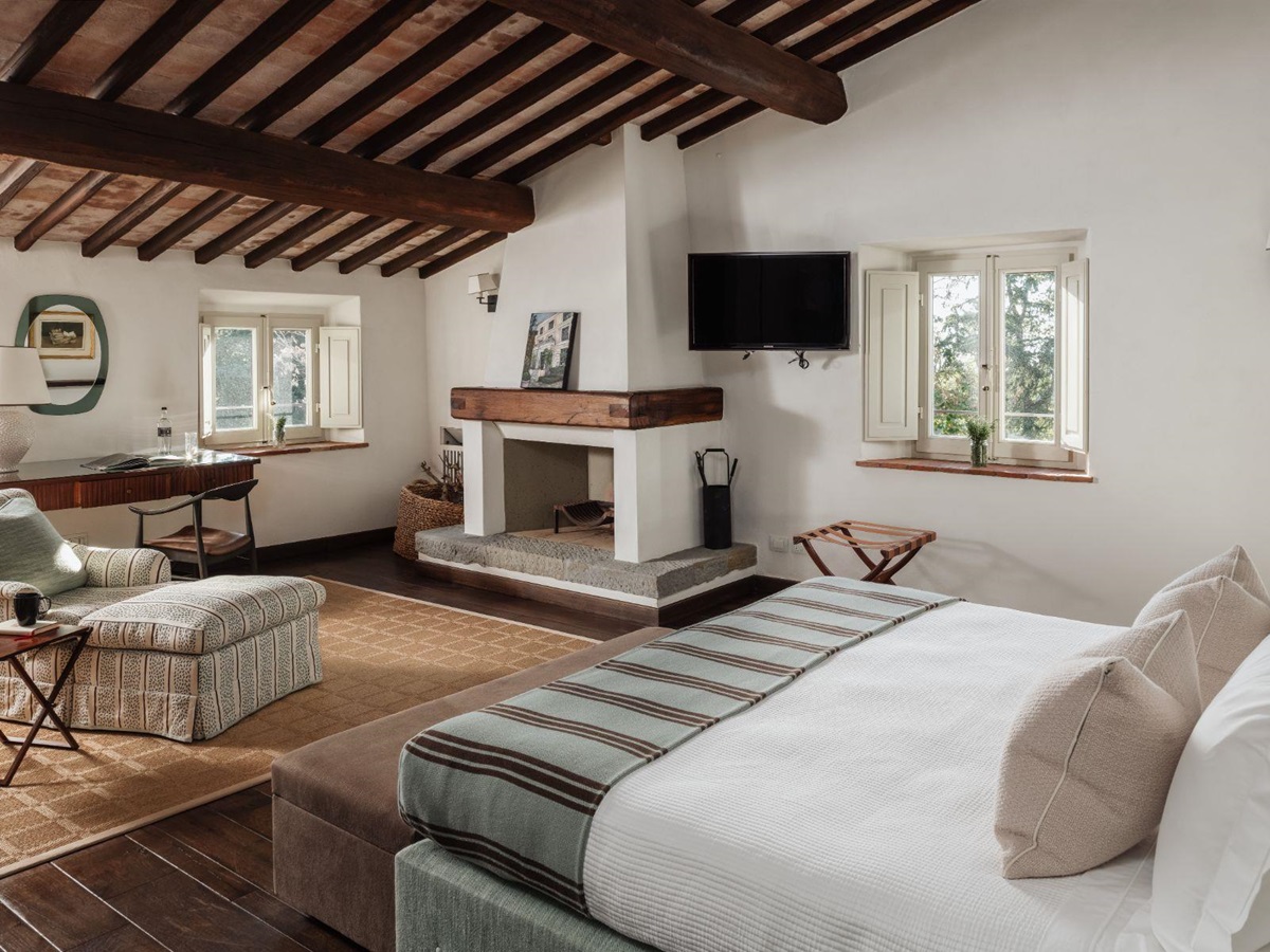 Large bedroom with double bed and fireplace at Tramonti in Tuscany