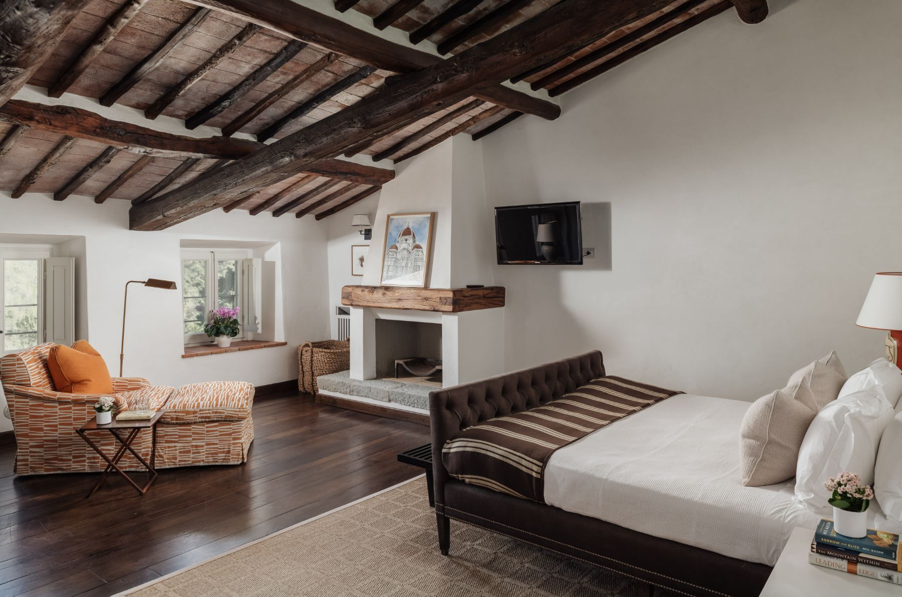 Bedroom with double bed and orange armchair at Tramonti in Tuscany