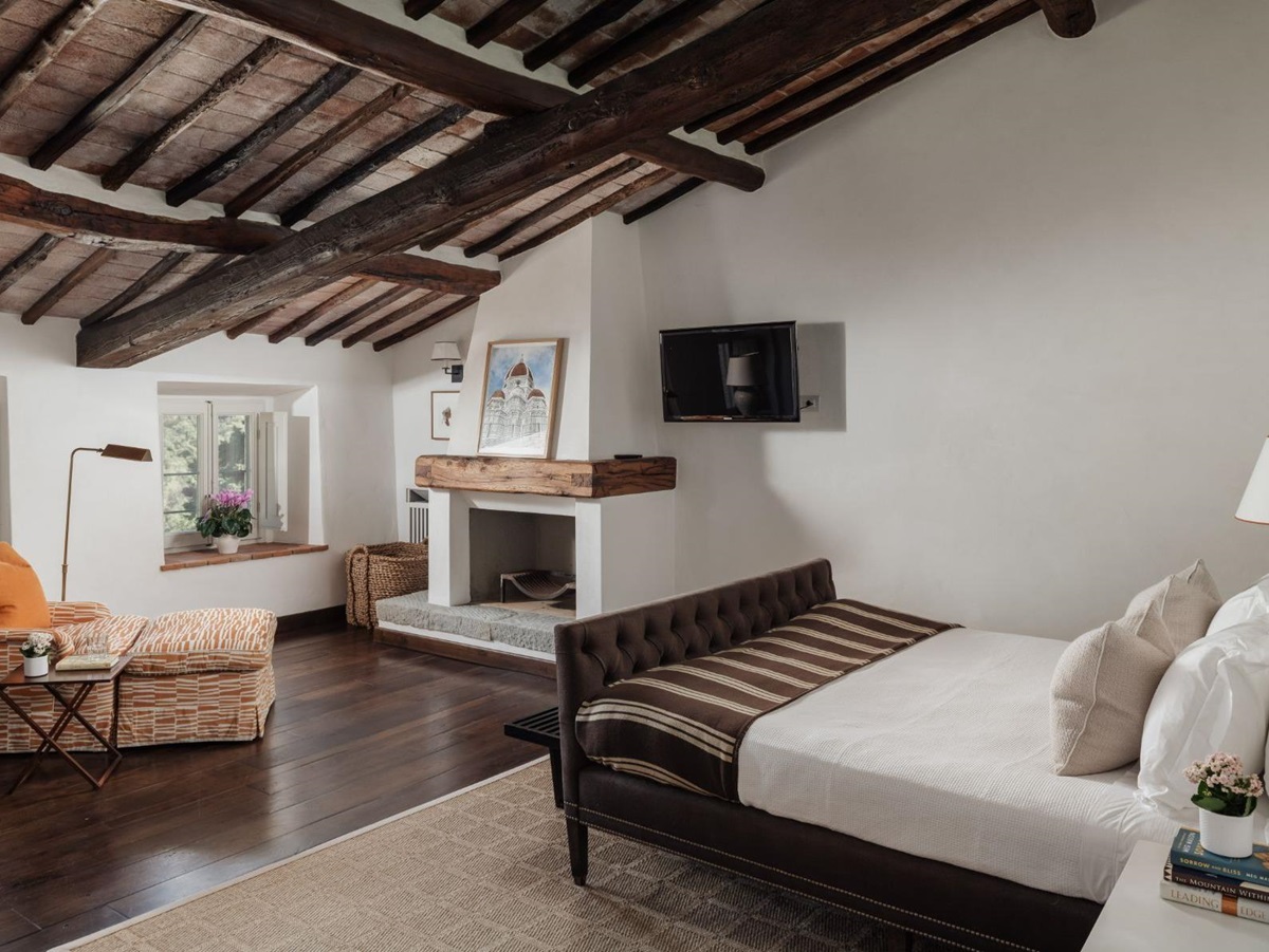 Bedroom with double bed and orange armchair at Tramonti in Tuscany