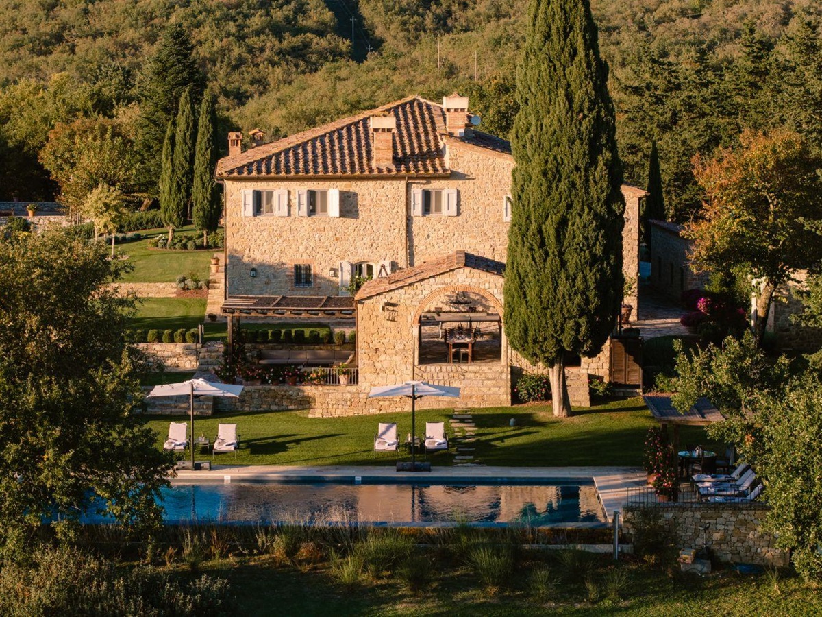 View of the front of Tramonti with view of the pool area surrounded by trees in Tuscany