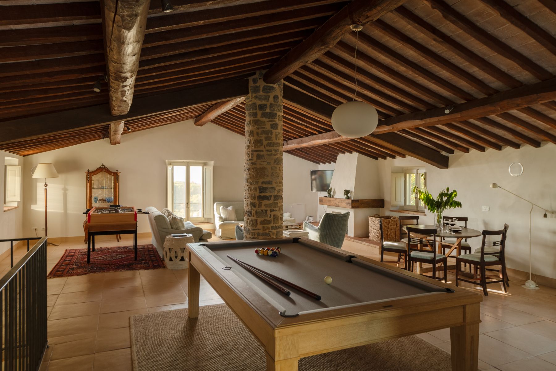 Indoor games room in the attic with pool table and sofas at Tramonti in Tuscany