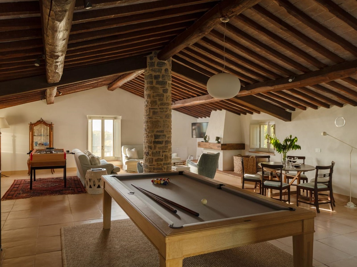 Indoor games room in the attic with pool table and sofas at Tramonti in Tuscany