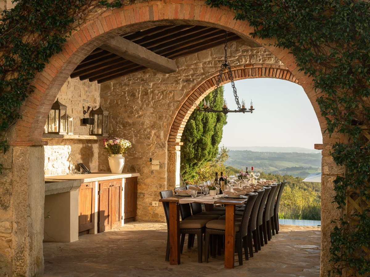 Outdoor dining area nearby to the pool area with a long table at Tramonti in Tuscany