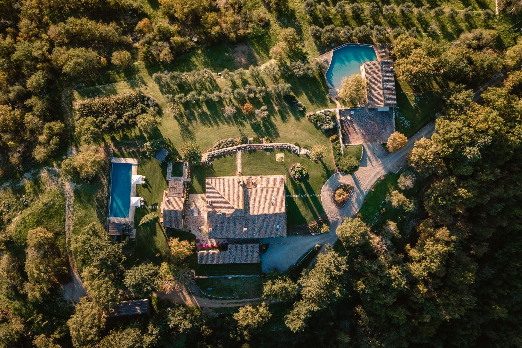 Overhead drone image of Tramonti in Tuscany with view of all the buildings and both pool areas