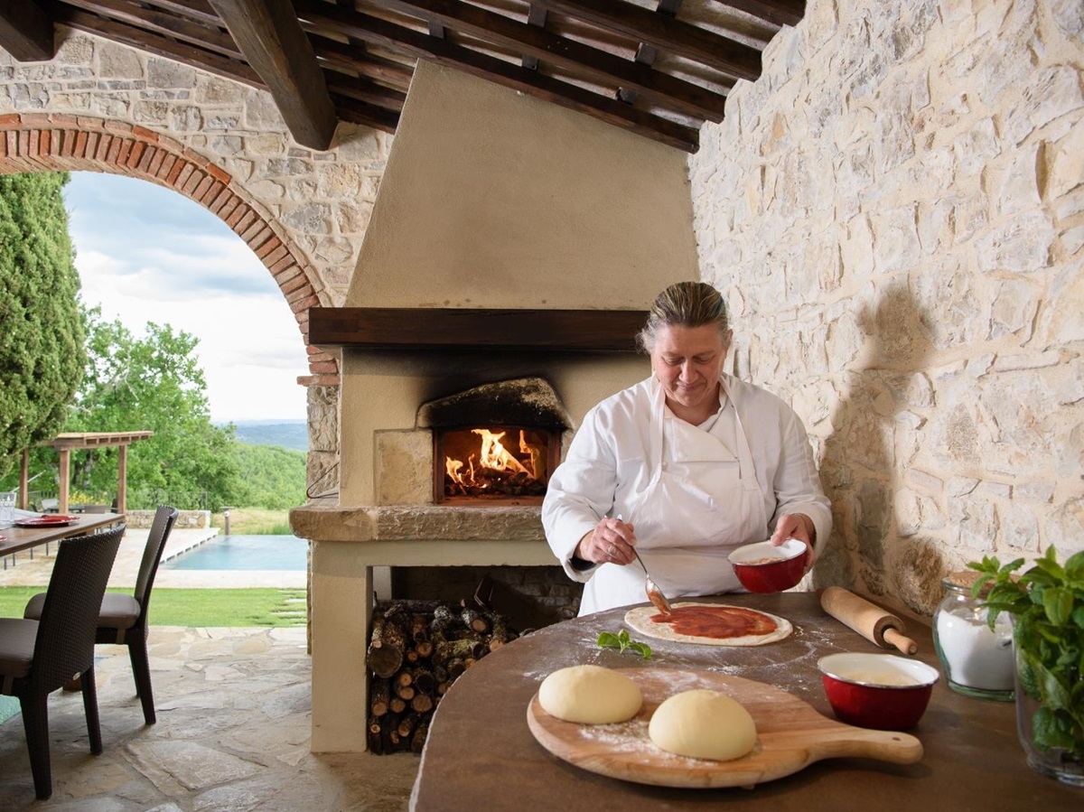 Pizza making by pool with wood fired pizza oven and chef at Tramonti in Tuscany, Italy