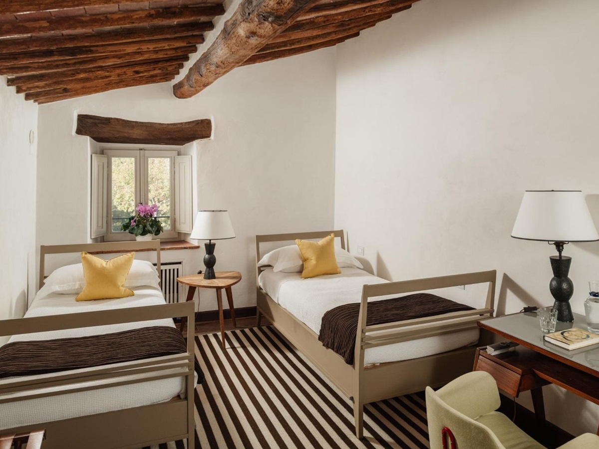 Twin room with striped carped and a desk at Tramonti in Tuscany