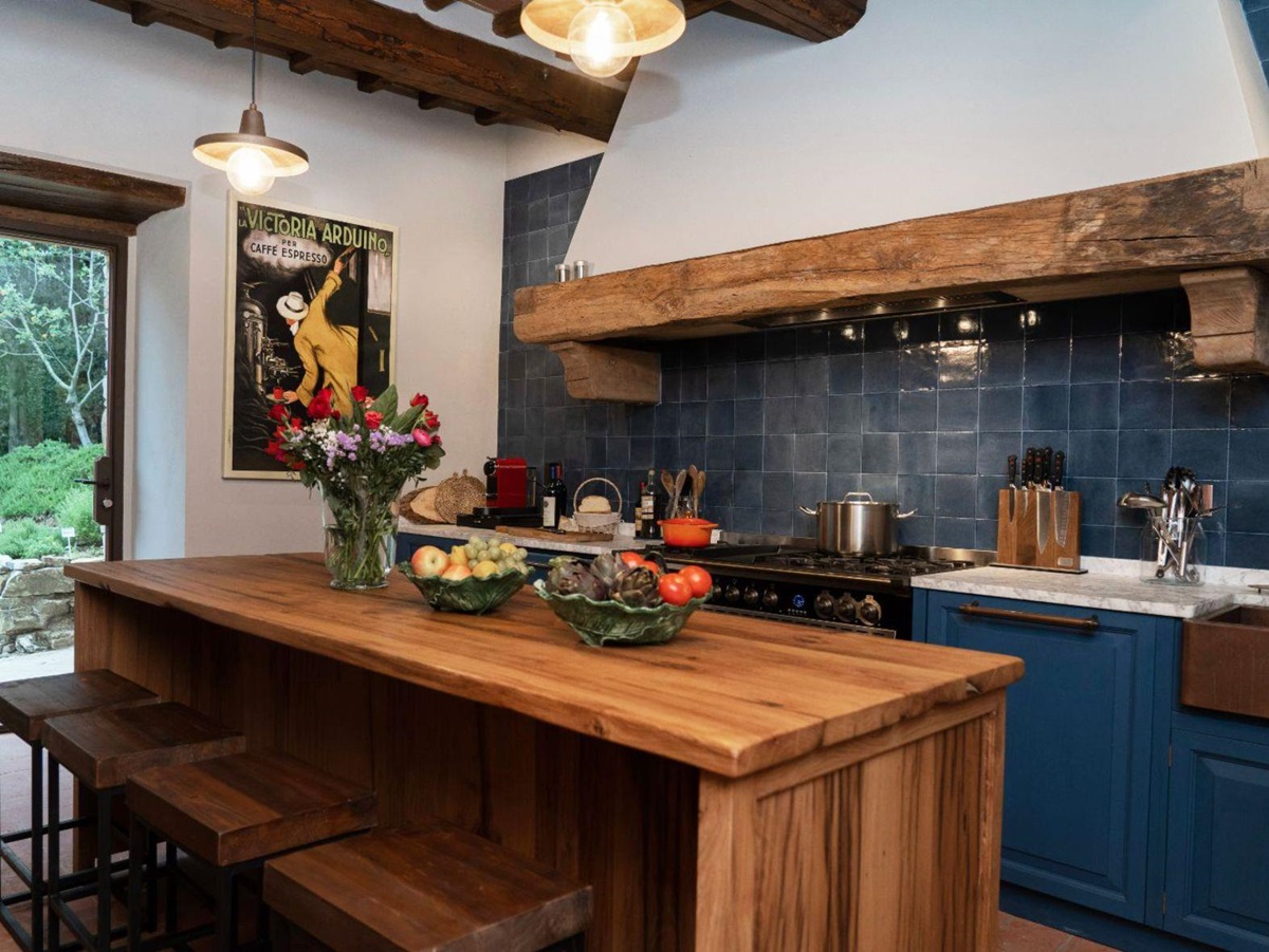 Kitchen with blue tiles and work tops and a wooden island at Villa Ardore in Tuscany