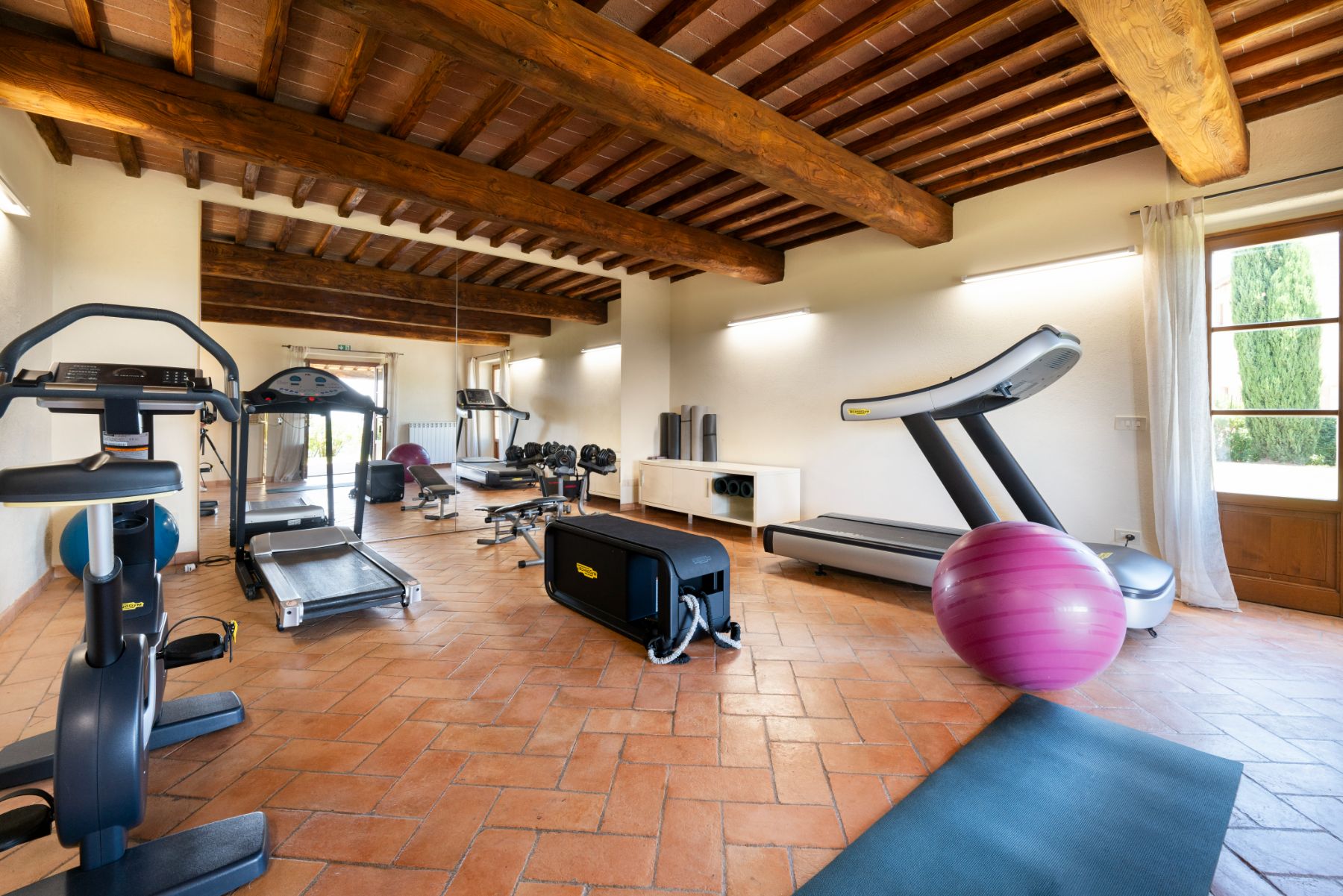 Gym room with running machine, mats and yoga ball in Villa Cispiano in Tuscany