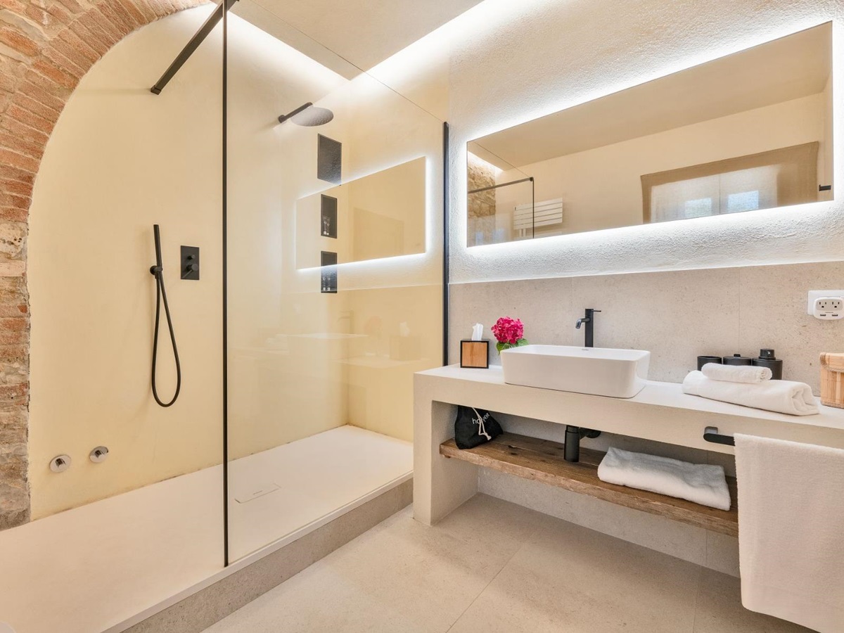 Bathroom with large mirror with lights in Villa Cispiano in Tuscany
