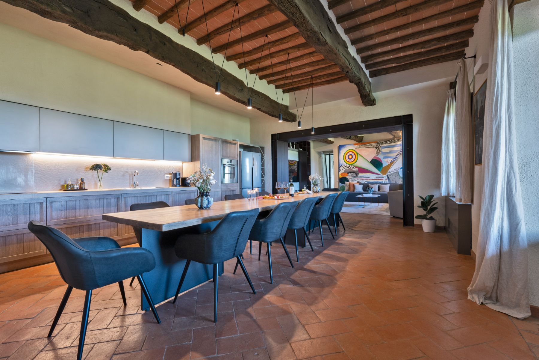 Indoor kitchen with long dining table in the middle at Villa Cispiano in Tuscany