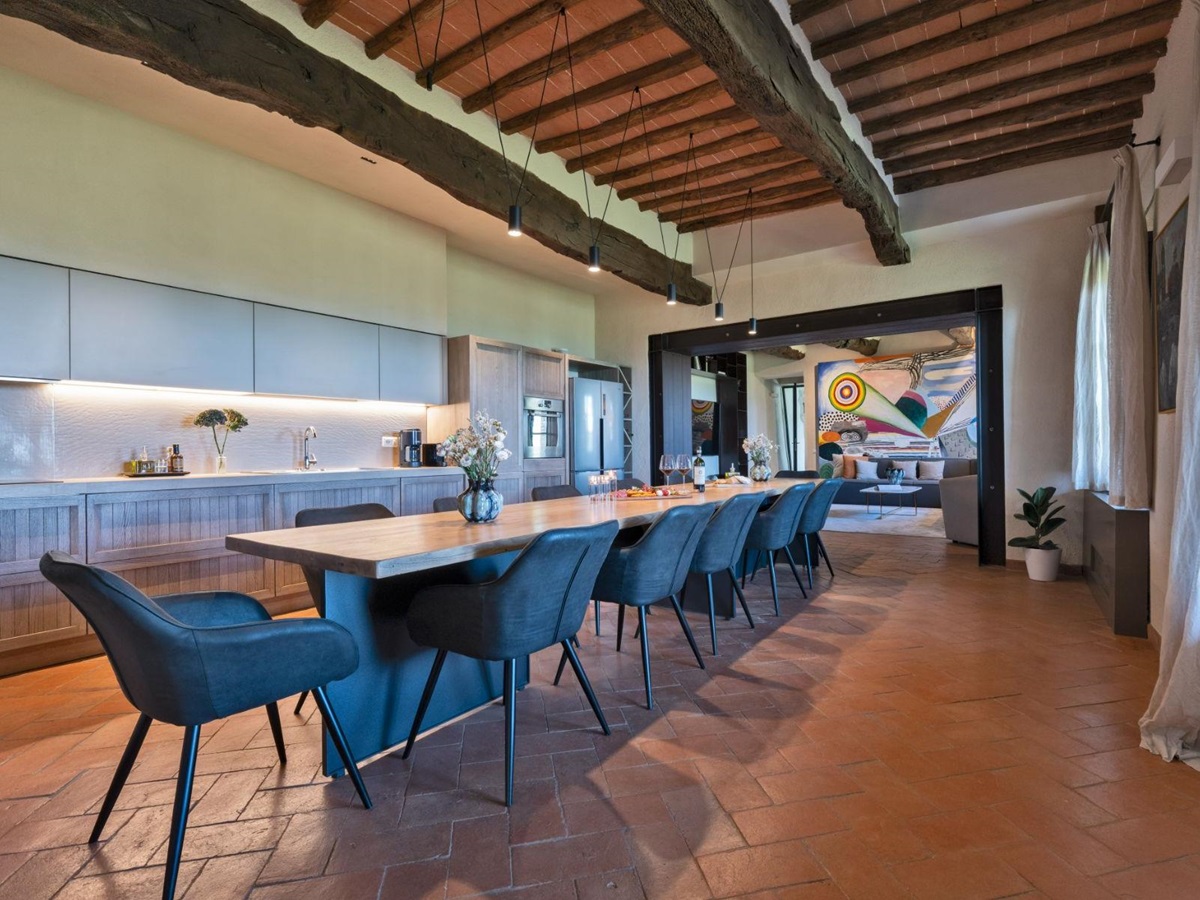 Indoor kitchen with long dining table in the middle at Villa Cispiano in Tuscany