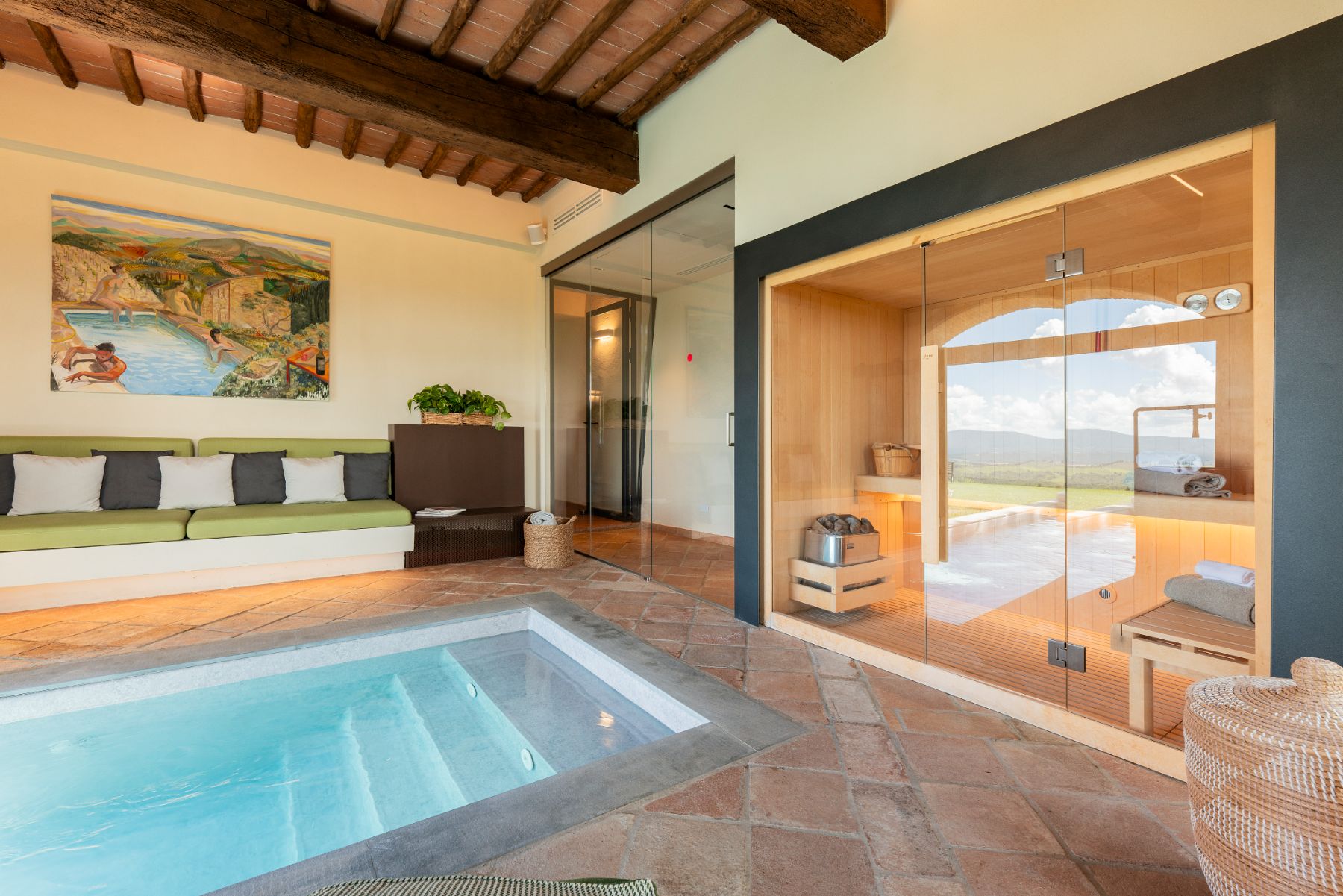 Indoor pool with view of seating area and sauna at Villa Cispiano in Tuscany