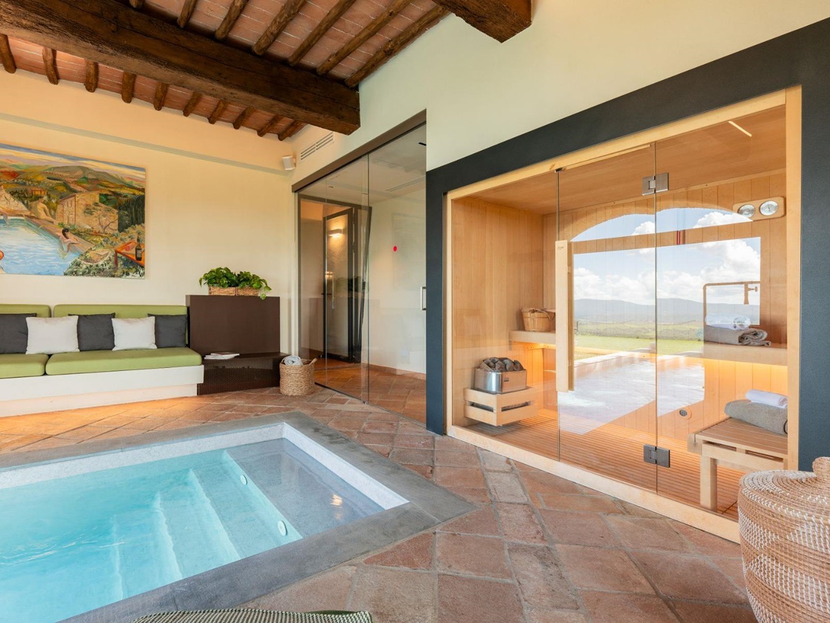 Indoor pool with view of seating area and sauna at Villa Cispiano in Tuscany