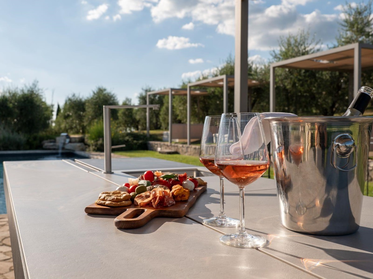 Outdoor table with Il Cellese wine by the pool at Villa Cispiano in Tuscany