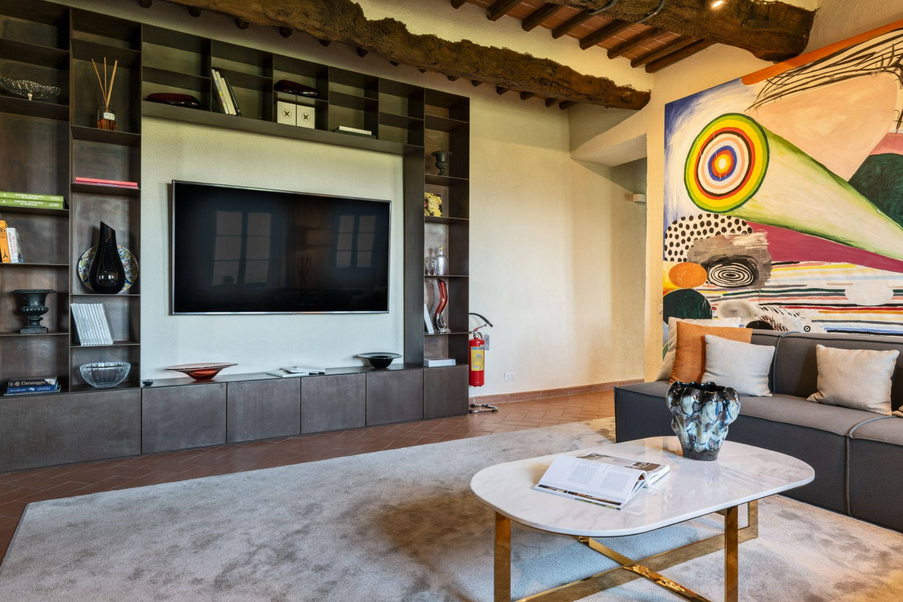 television room with sofas and large television on the wall at Villa Cispiano in Tuscany