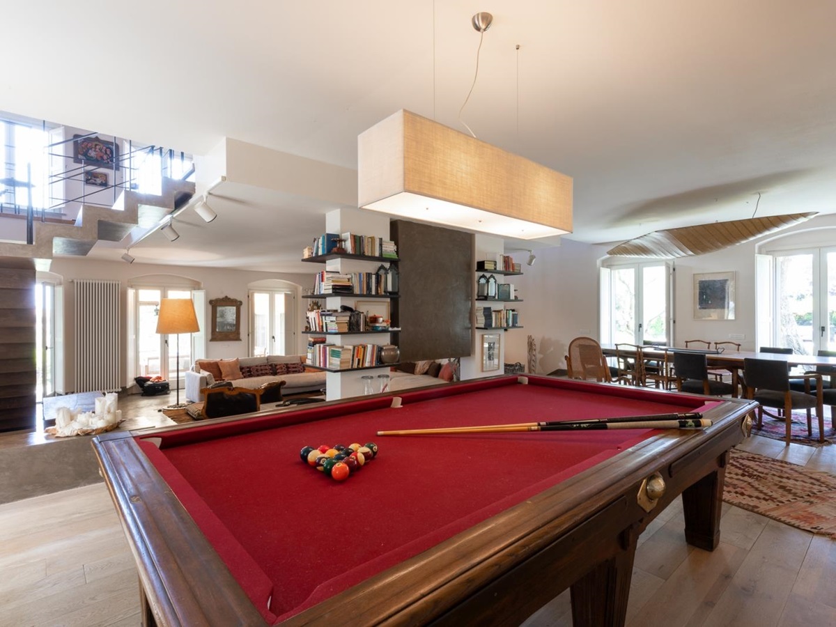 Red billiard table with dining area in backhground at Villa del Gelso, Tuscany