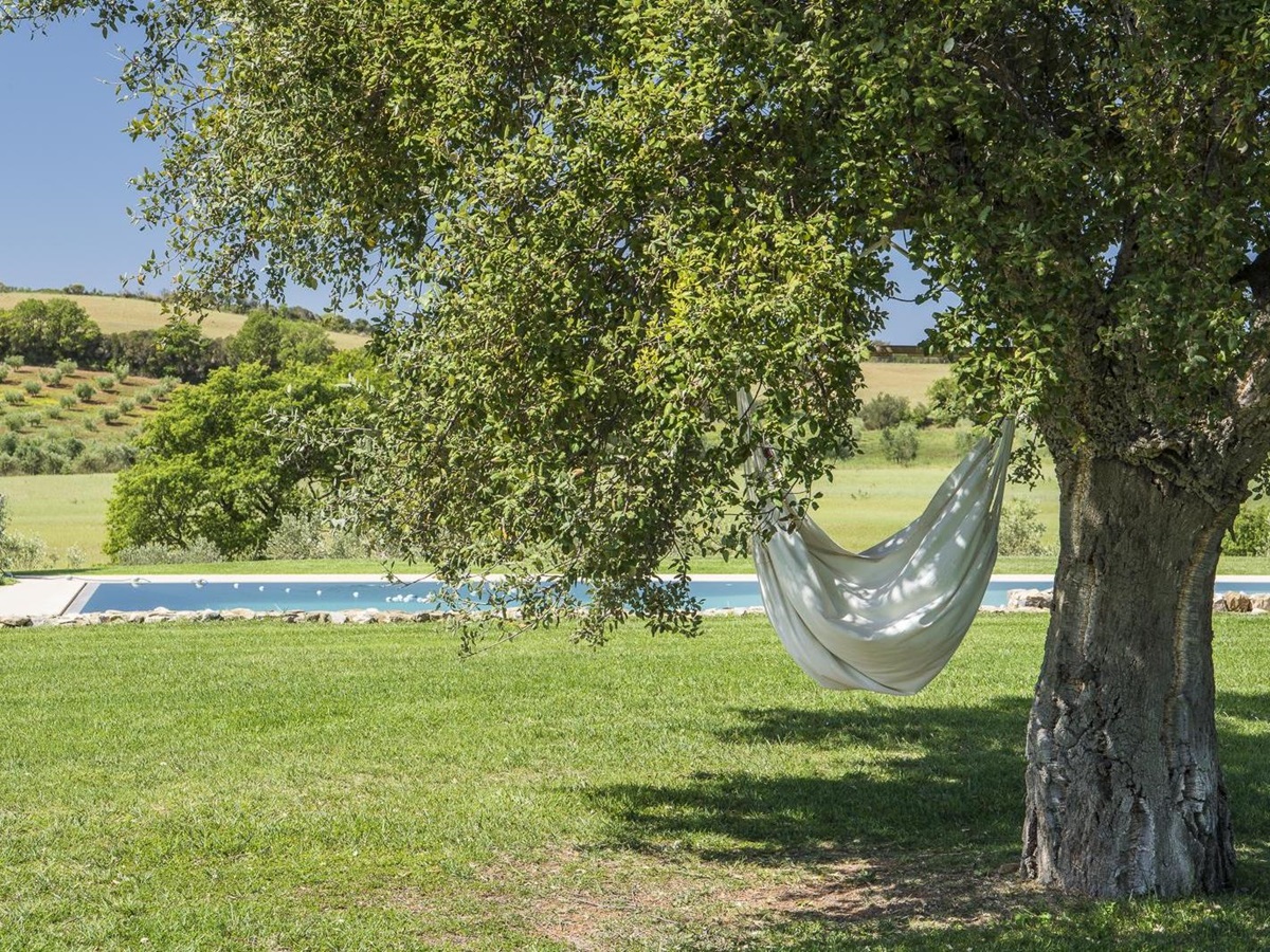 Hammock and swimming pool in the garden of Villa del Gelso, Tuscany