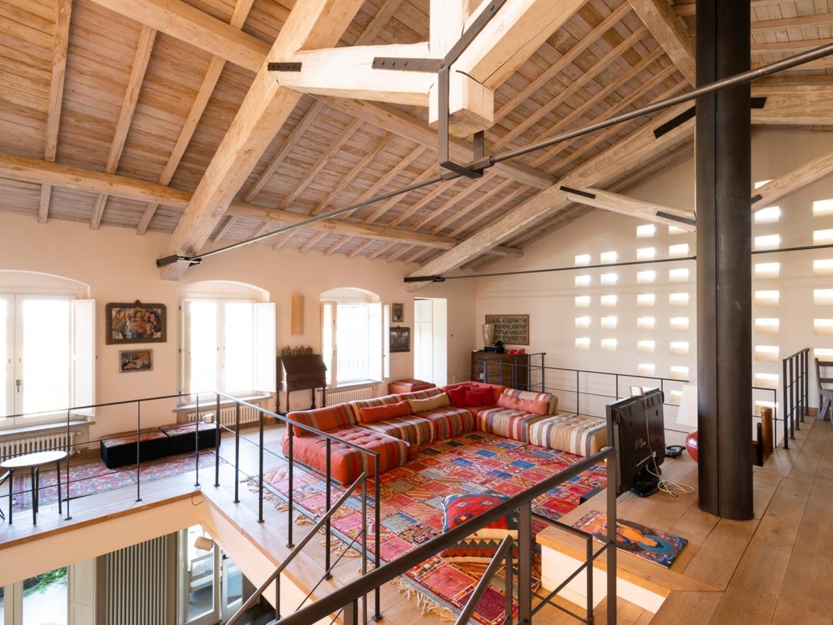 Upstairs living room with red sofa and rug at Villa del Gelso, Tuscany