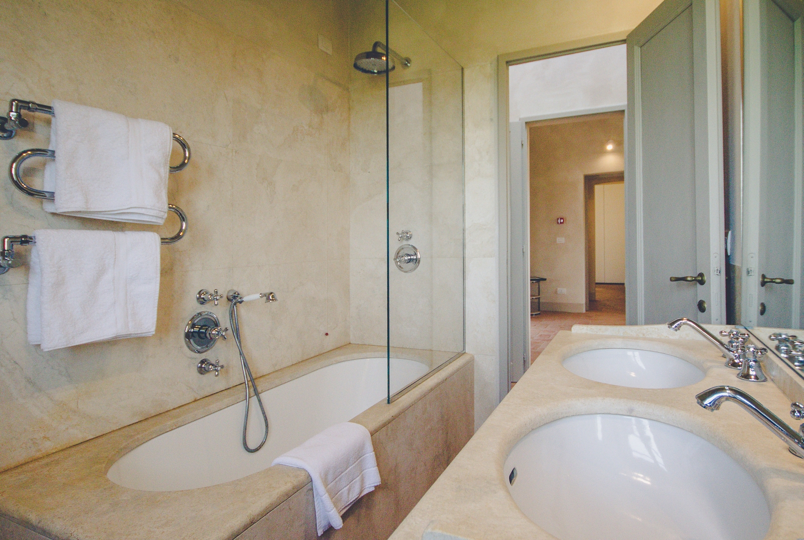 Bathroom with double sink, bath shower and towel rail at Villa dell’Angelo in Tuscany, Italy