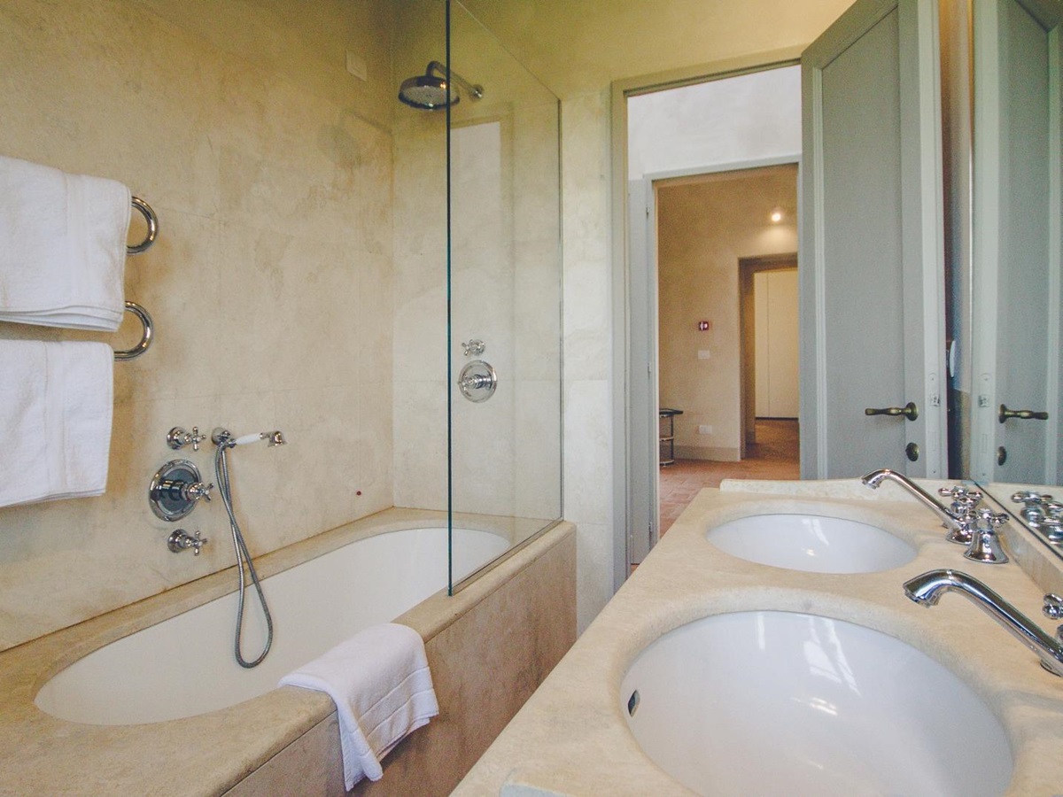 Bathroom with double sink, bath shower and towel rail at Villa dell’Angelo in Tuscany, Italy