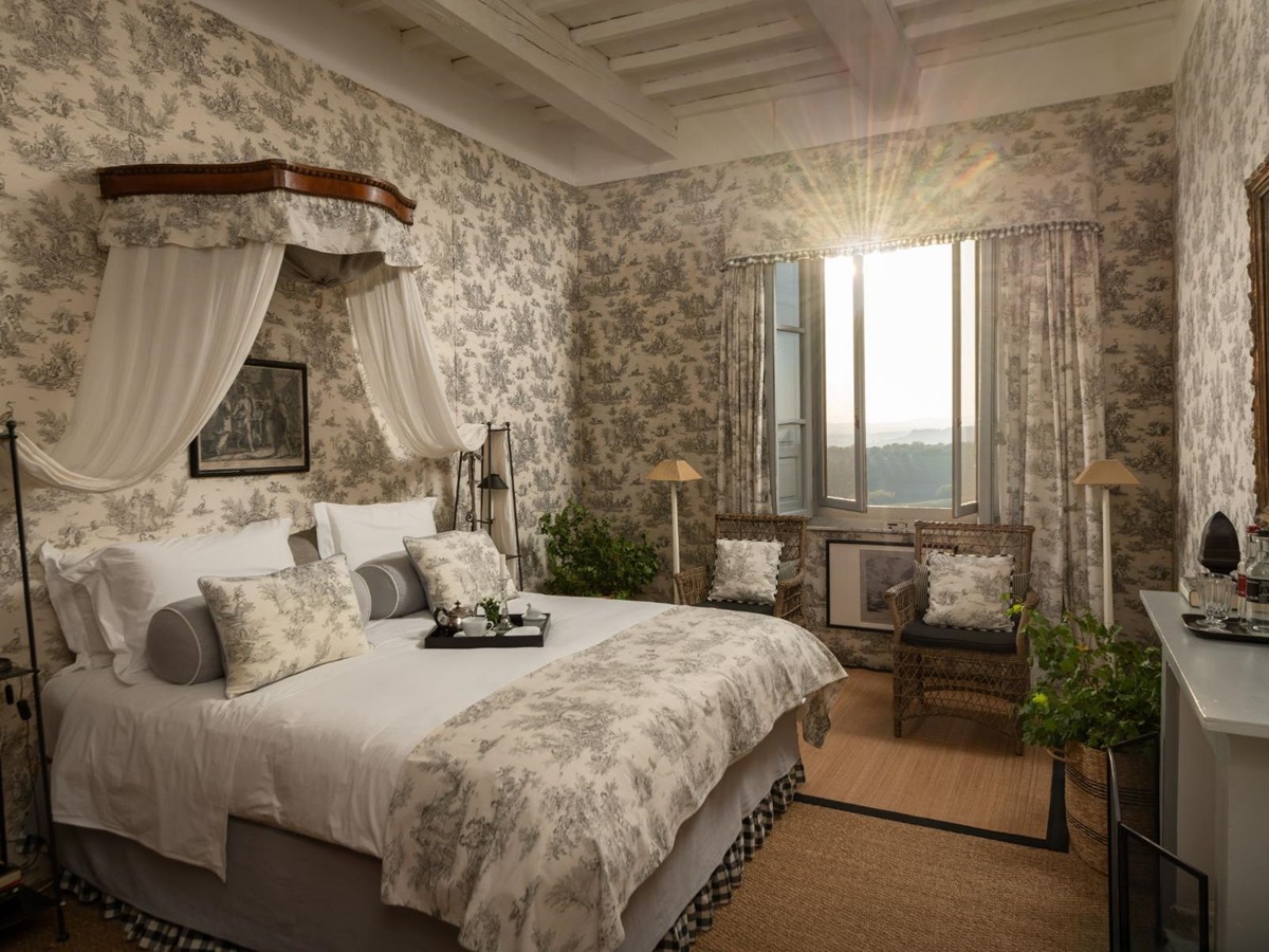 Large bedroom with double bed and armchairs at Villa delle Vigne in Tuscany