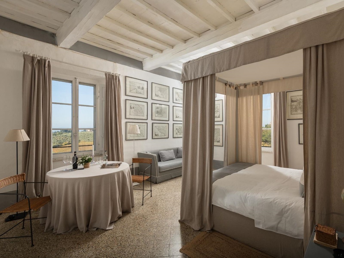 Large bedroom with double bed and a table and chairs at Villa delle Vigne in Tuscany