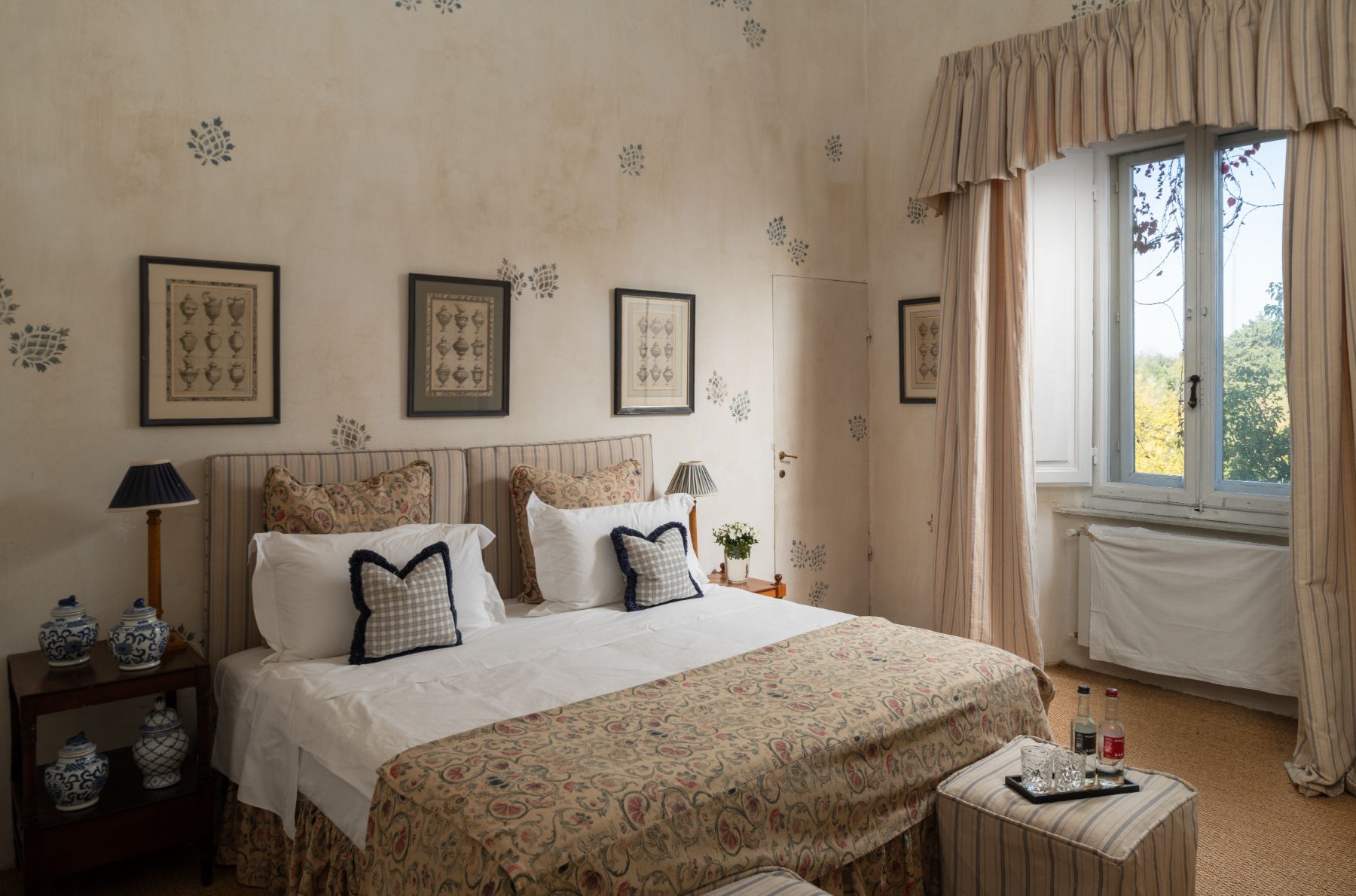 Large bedroom with double bed and a window with curtains at Villa delle Vigne in Tuscany