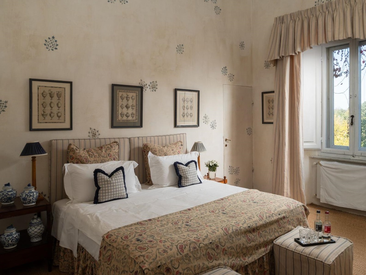 Large bedroom with double bed and a window with curtains at Villa delle Vigne in Tuscany