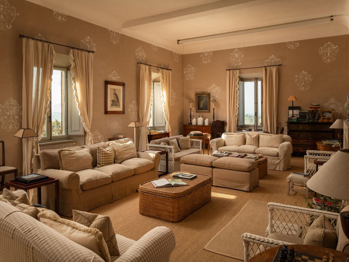 Living room with four large sofas and a wooden cabinet at Villa delle Vigne in Tuscany