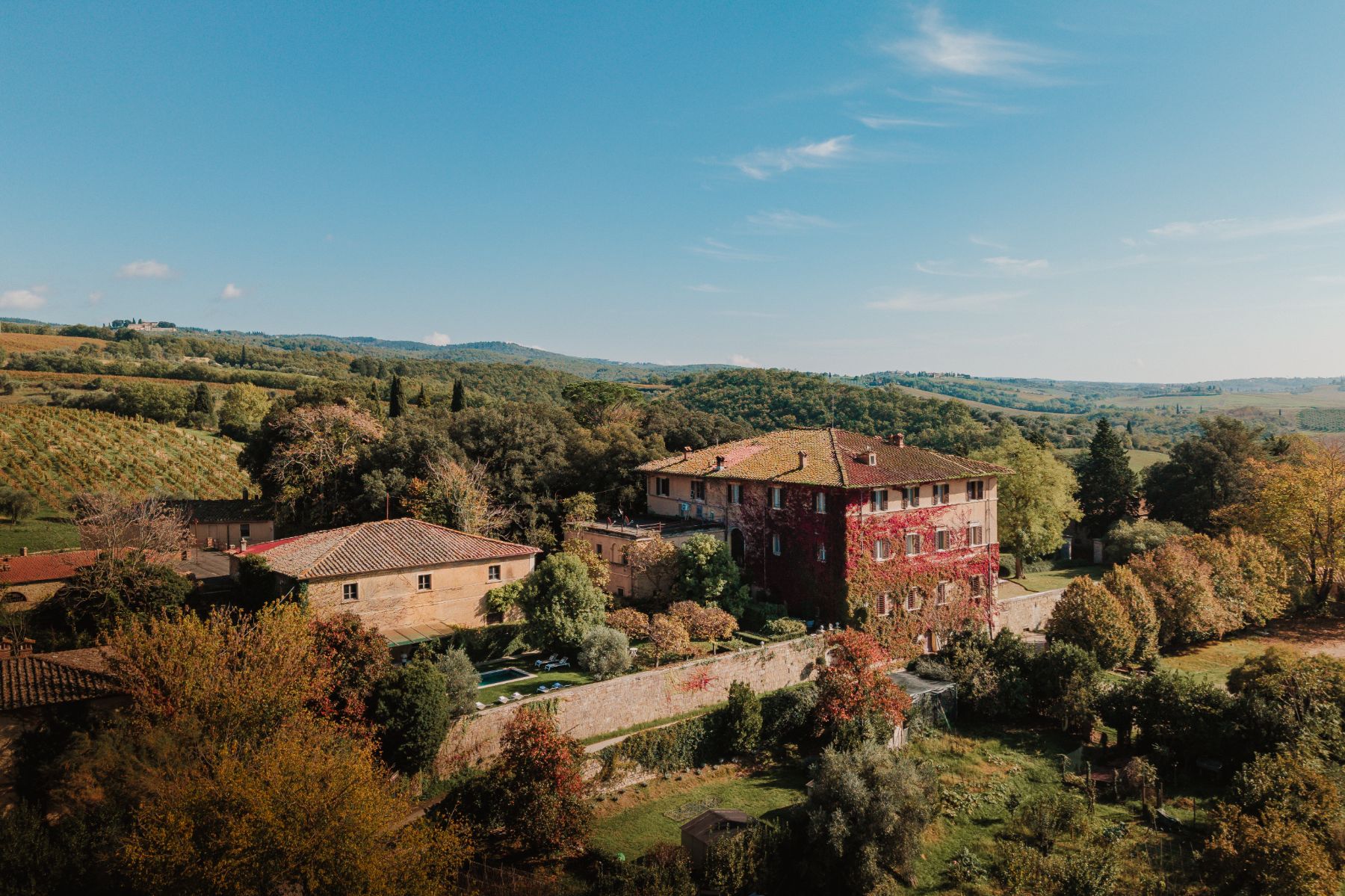 Drone view of Villa delle Vigne in Tuscany with view of the outdoor pool and surrounding trees