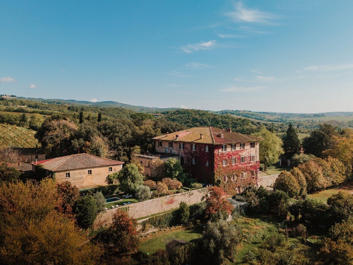 Drone view of Villa delle Vigne in Tuscany with view of the outdoor pool and surrounding trees