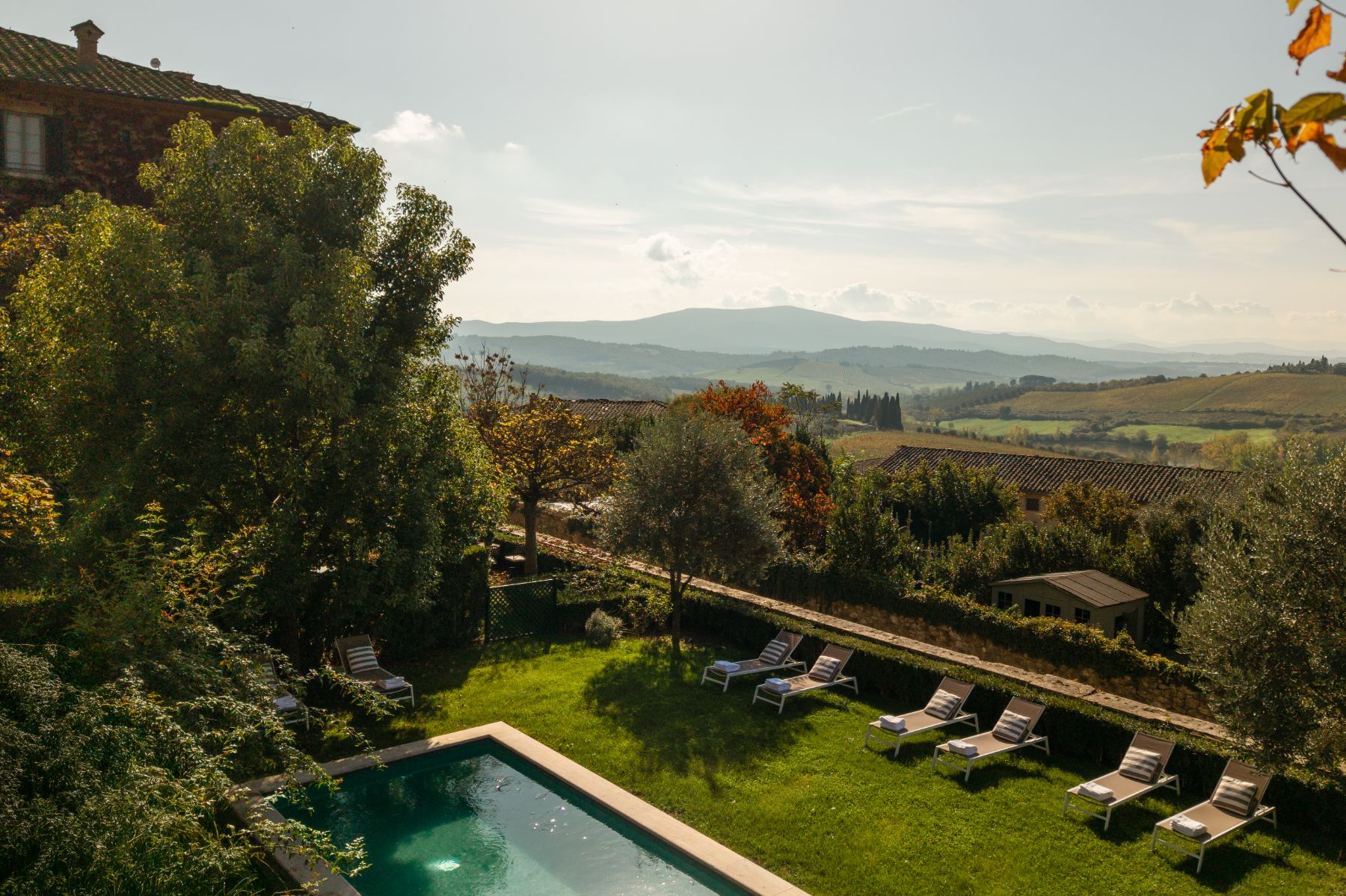 Drone view of the outdoor pool area at Villa delle Vigne in Tuscany with view of the hills