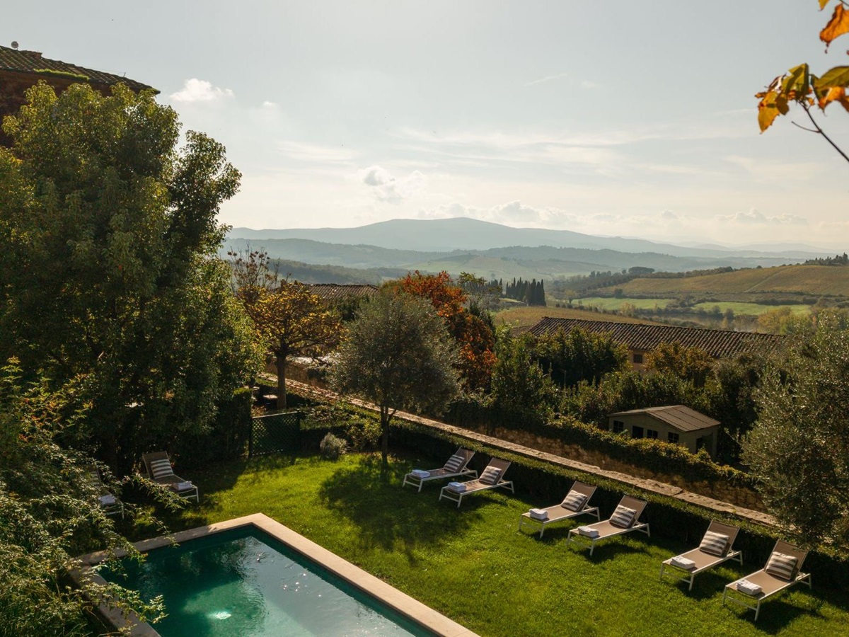 Drone view of the outdoor pool area at Villa delle Vigne in Tuscany with view of the hills