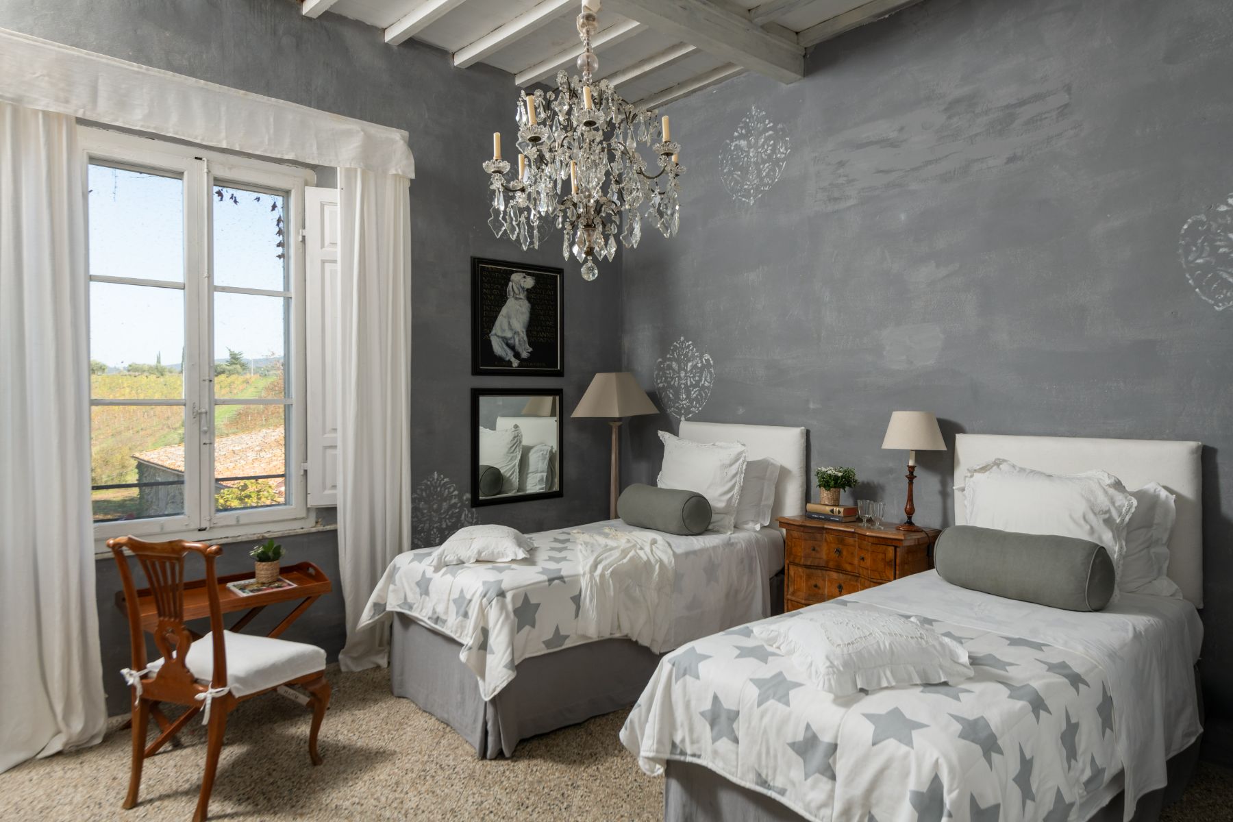Twin room with a chandelier and wooden chair at Villa delle Vigne in Tuscany