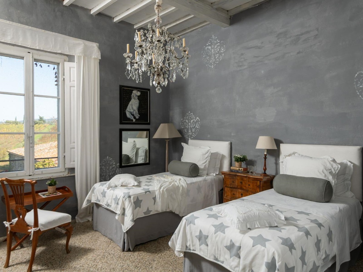 Twin room with a chandelier and wooden chair at Villa delle Vigne in Tuscany