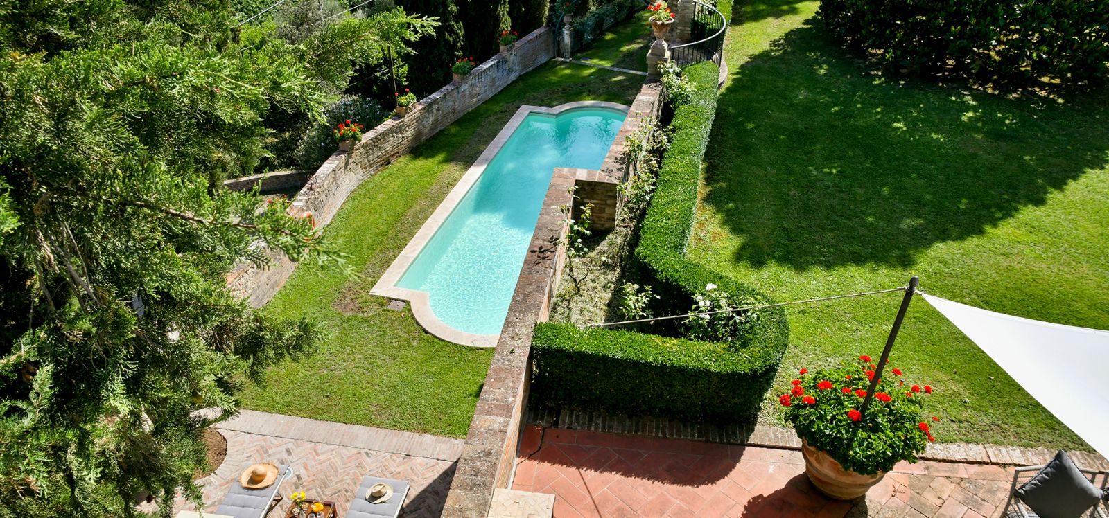 Garden with large tree and villa exterior at Villa di Renai in Tuscany
