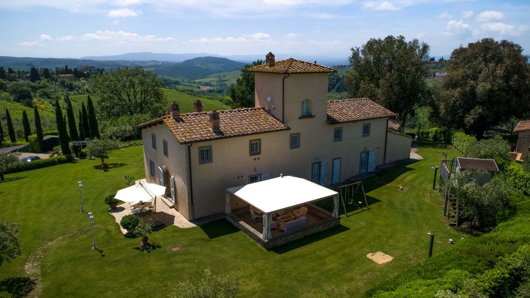 Back of Villa di Tignano in Tuscany with view of the play area and outdoor dining 