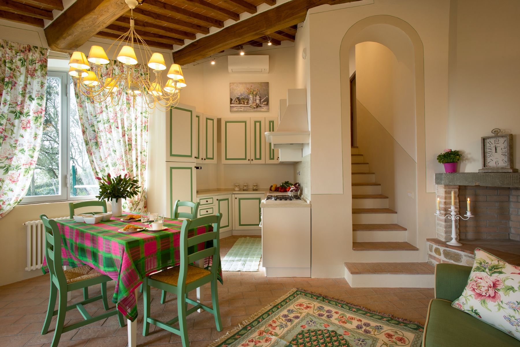 Kitchen area with green and pink furniture in the dependence at Villa di Tignano in Tuscany