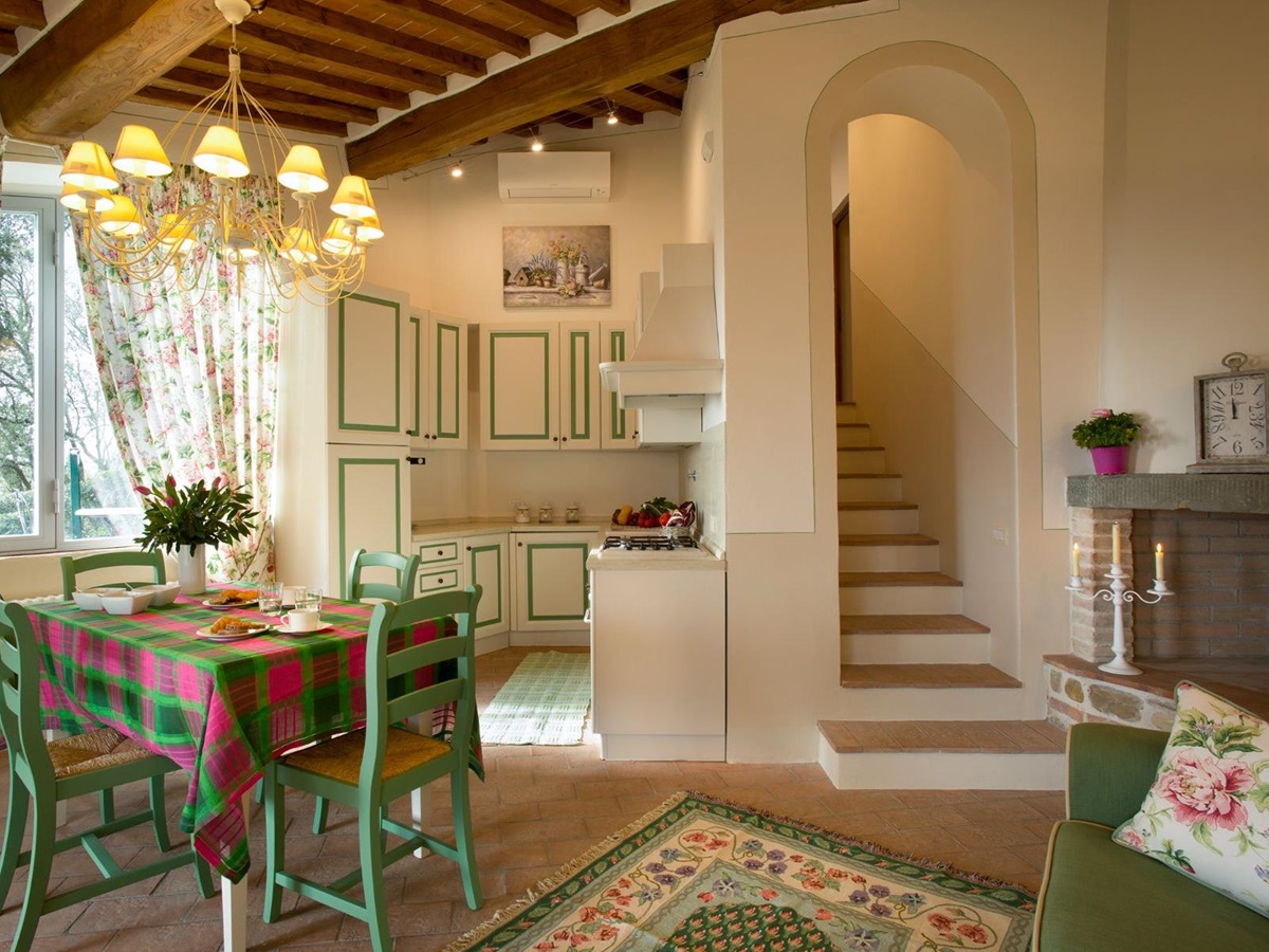 Kitchen area with green and pink furniture in the dependence at Villa di Tignano in Tuscany