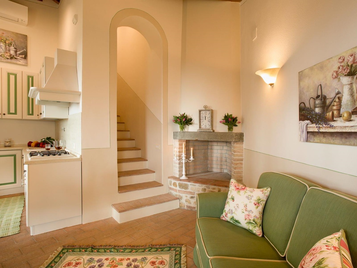 Green sofa and stairs in the ground floor of the dependance at Villa di Tignano in Tuscany